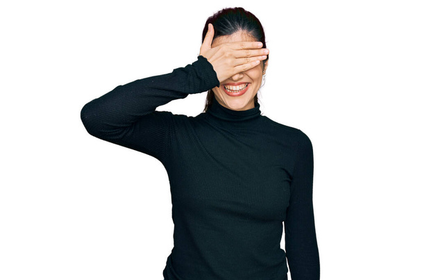 Young hispanic woman wearing casual clothes smiling and laughing with hand on face covering eyes for surprise. blind concept.  - Foto, immagini