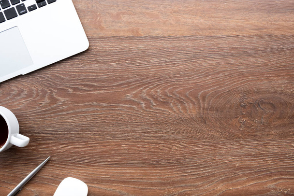 Table de bureau en bois avec ordinateur portable, tasse de café et fournitures. Vue du dessus avec espace de copie, plan plat. - Photo, image