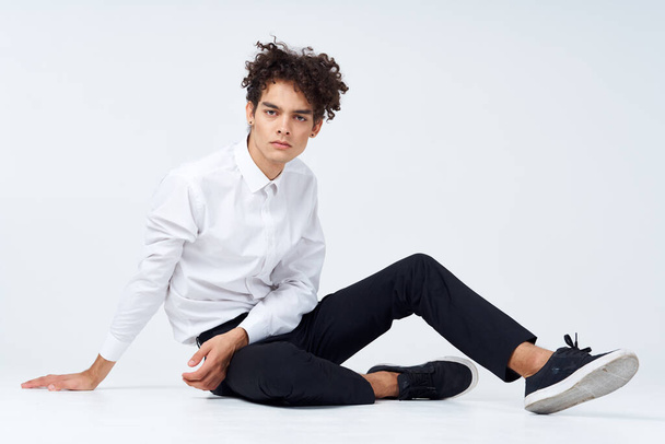 adolescent en baskets, pantalon noir et une chemise blanche Dans une pièce lumineuse en pleine croissance - Photo, image