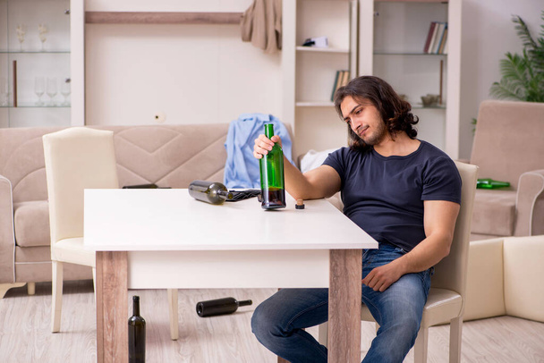 Young unemployed man drinking alcohol at home - Photo, Image