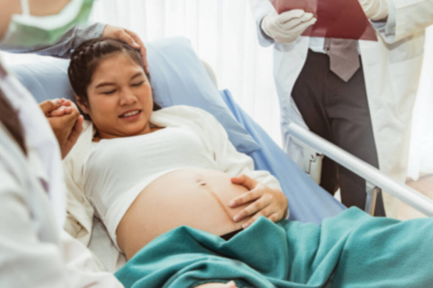Rozmazané fotografie Tým lékařů a ženských lékařů pomáhají sledovat stav a zdraví těhotných žen s péčí a povzbuzování a dobré. Doufám, že relaxovat před porodem: rozmazané pozadí - Fotografie, Obrázek