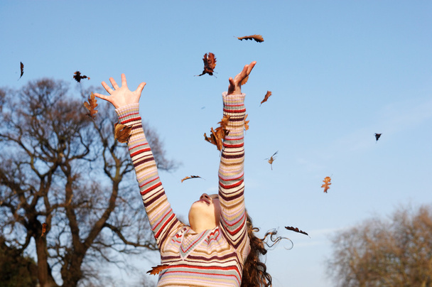 Chica lanzando hojas de otoño
 - Foto, imagen