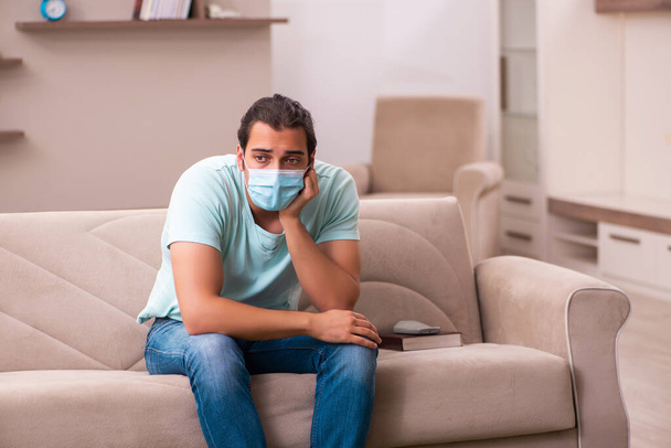 Young man sitting at home during pandemic - Foto, Imagen