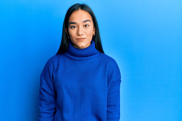 Young asian woman wearing casual winter sweater relaxed with serious expression on face. simple and natural looking at the camera.  - Φωτογραφία, εικόνα