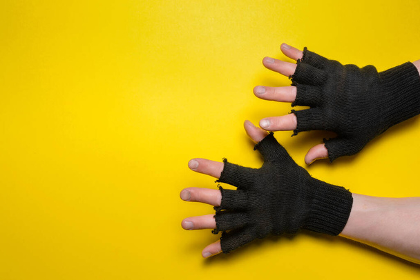 Male hands in the black construction gloves on the yellow flat lay background. - Foto, immagini