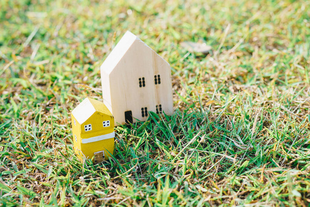 Dřevěné hračky dům model na zelené trávě nový domácí obchodní koncept - Fotografie, Obrázek