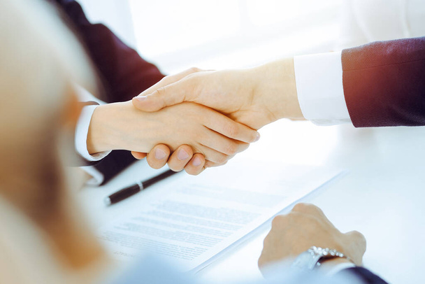 Businesspeople or lawyers shaking hands finishing up meeting or negotiation in sunny office. Business handshake and partnership - Foto, Imagen