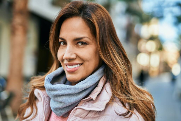 Joven mujer hispana sonriendo feliz de pie en la ciudad. - Foto, imagen