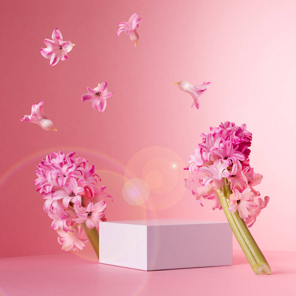 Fashion pastel pink mock up with white square podium for presentation cosmetic, accessories and produce in sunlight with levitate spring hyacinth flowers and sun flares, square. - Fotografie, Obrázek