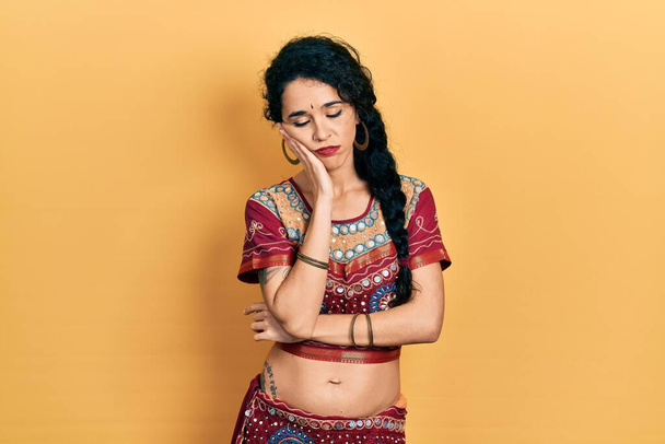 Молодая женщина в бинди и болливудской одежде думает устало и скучно с депрессией проблемы со скрещенными руками.  - Фото, изображение