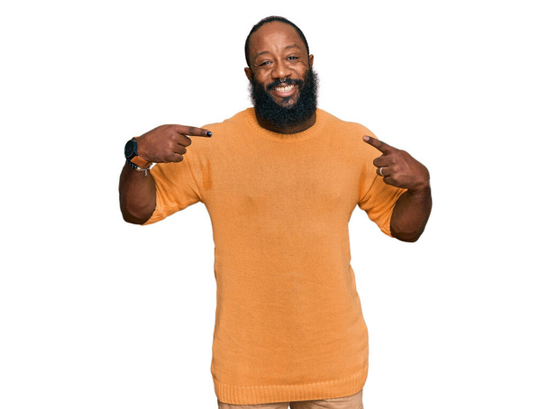 Joven hombre afroamericano vistiendo ropa casual buscando confiado con sonrisa en la cara, señalándose con los dedos orgullosos y felices.  - Foto, Imagen