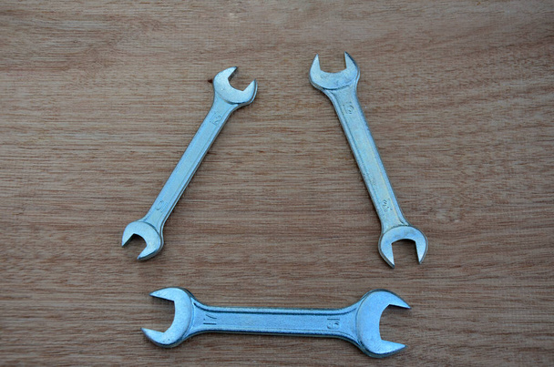 Spanners. Many wrenches. Industrial background. Set of wrench tool equipment. Set of wrenches in different sizes.New keys on wood background, top view with space for text. - Photo, Image
