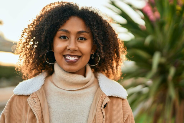 Молода афроамериканська жінка, яка радісно посміхається біля міста.. - Фото, зображення