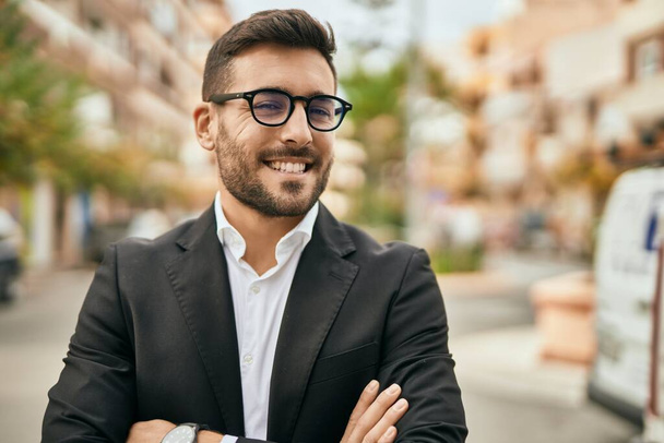 Young hispanic businessman with arms crossed smiling happy at the city. - Photo, Image