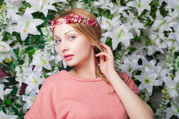 Beautiful and fashion young woman near the wall of flowers - Fotoğraf, Görsel