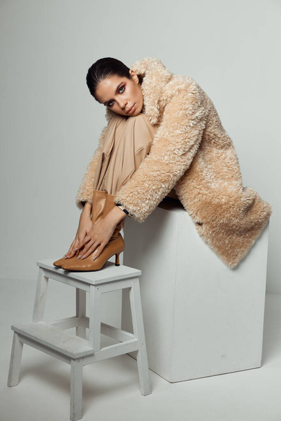 roztomilý bruneta dát její nohy na stůl hnědé boty podzim móda - Fotografie, Obrázek