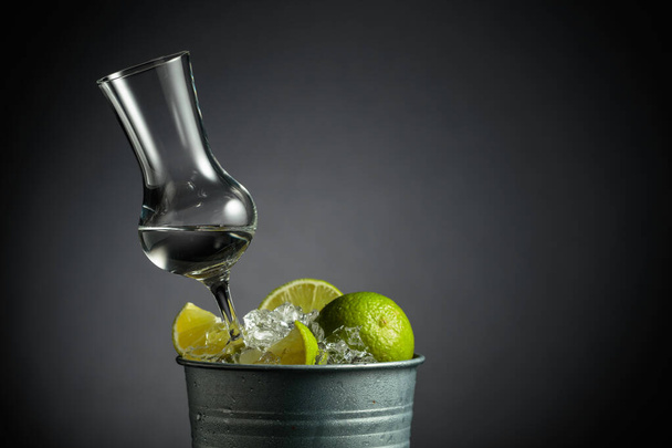 Tequila con clices di calce in un secchio di metallo con ghiaccio. Copia spazio. - Foto, immagini