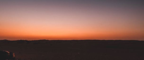 Een zonsondergang achtergrond - paarse en oranje ombre hemel aan de horizon - Foto, afbeelding