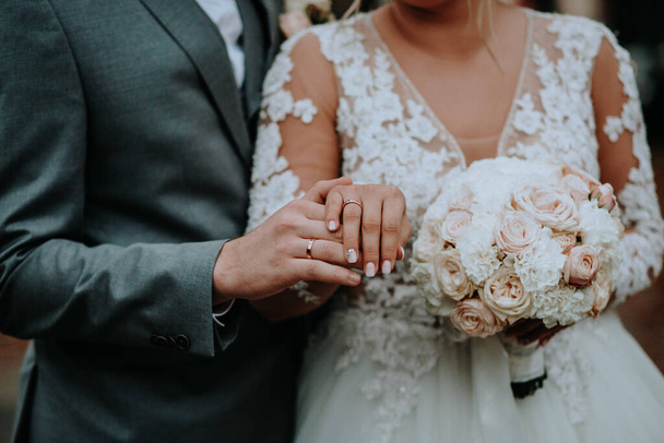 A closeup shot of a wedding couple holding hands, groom and bride - Foto, Bild