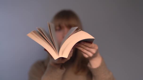Educational concept. Young girl leafing through an open book - Footage, Video