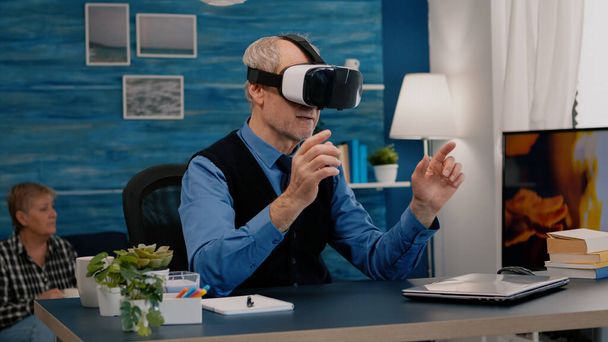 Hombre jubilado experimentando realidad virtual usando auriculares vr en la sala de estar - Foto, imagen