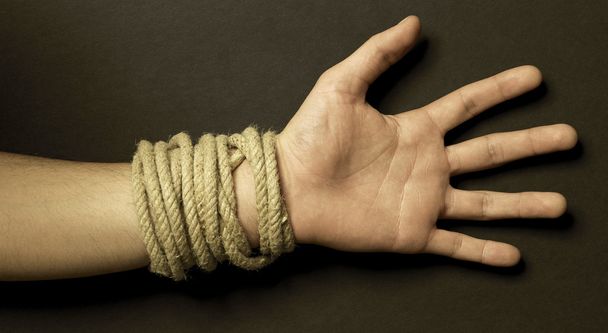Hand with a rope with black background - 写真・画像