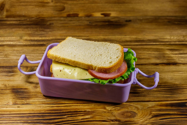 Scatola pranzo con panini su un tavolo di legno - Foto, immagini