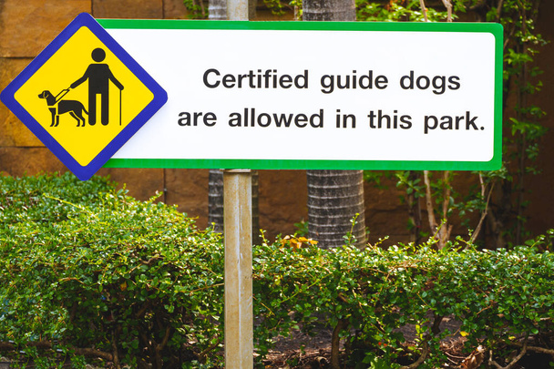 Certyfikowany znak psa przewodnika dla osób niedowidzących na starym drogowskazie w parku publicznym - Zdjęcie, obraz