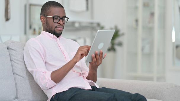 Evde Dijital Tablet kullanan Gevşek Afrikalı Adam  - Fotoğraf, Görsel