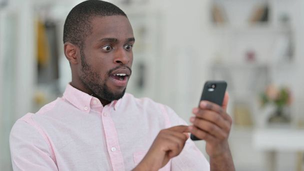 Retrato del hombre africano leyendo a la pérdida en el teléfono inteligente, el fracaso
  - Foto, imagen