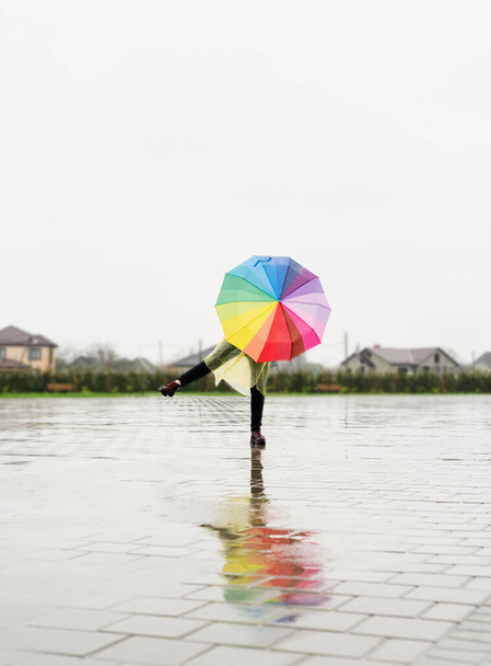γυναίκα κρατώντας πολύχρωμη ομπρέλα χορεύει στη βροχή - Φωτογραφία, εικόνα
