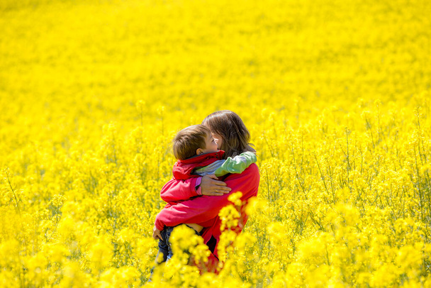 Madre e hijo paseando por los campos de colza - Foto, imagen