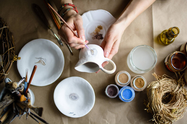 Процесс рисования вручную керамической посуды ручной работы. Селективный фокус. - Фото, изображение