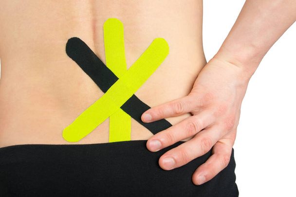 on the back of the back, taped kinesio to relieve lower back pain, after injury - Foto, Imagen