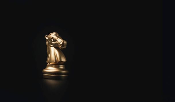 Golden knight horse chess on black background, business strategy concept. - Photo, Image