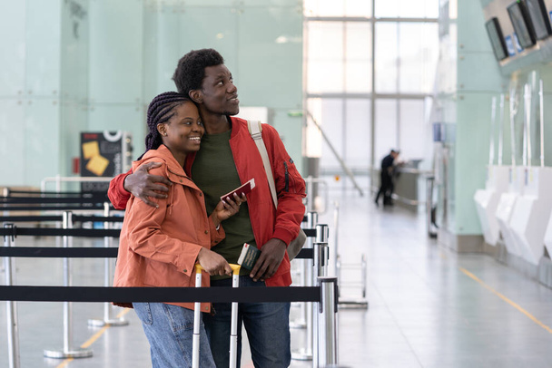 Free to travel. African couple wait check-in for flight after covid disease end. Back to normal. - Foto, imagen