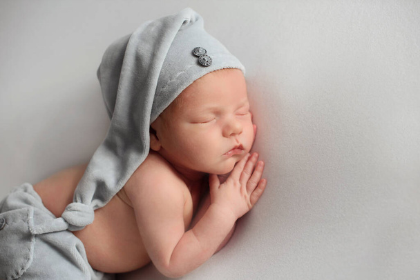 Niño recién nacido en un sombrero de punto azul - Foto, imagen