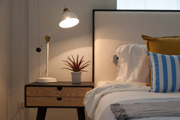 side table lamp in white, yellow and blue cozy bedroom. - Foto, imagen