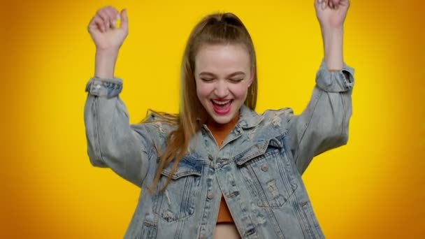 Chica adolescente en chaqueta de mezclilla gritando, levantando los puños en gesto lo hice, celebrando el éxito, ganando - Metraje, vídeo
