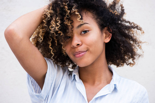 Close up portret piękna młoda czarna kobieta z ręką w kręcone włosy - Zdjęcie, obraz