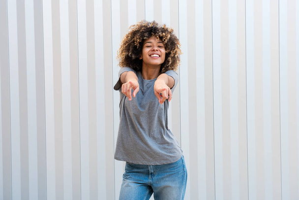 Portré boldog mosolygós afro-amerikai lány ujjal mutogat - Fotó, kép