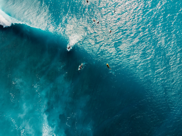 Luftaufnahme von Surfern im tropischen blauen Ozean mit Wellen auf der Insel Bali. Ansicht von oben - Foto, Bild
