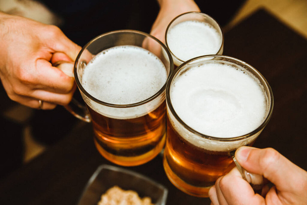 Three mugs of beer. Alcoholic drink made from wheat. Beautiful foam and bubbles on the beer. - Φωτογραφία, εικόνα