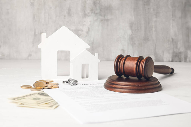 Judge's gavel with figures of house and money on light background - Photo, Image