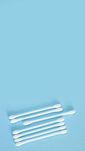 Flay lay de palos de algodón de plástico blanco o hisopos vista superior sobre fondo azul con espacio para copiar - Foto, Imagen