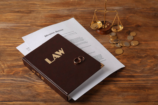 Βιβλίο νόμου με δαχτυλίδια και διάταγμα διαζυγίου σε ξύλινο φόντο - Φωτογραφία, εικόνα