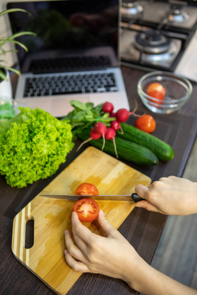felső kilátás konyha szakács asztal zöldségekkel laptop főzés recept - Fotó, kép