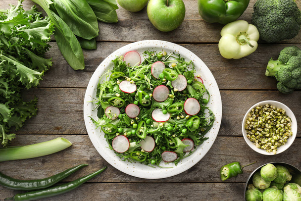 Placa de sabrosa ensalada con verduras frescas sobre fondo de madera - Foto, Imagen
