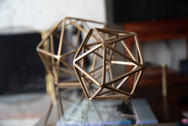 Metal geometric tabletop home decoration. Polyhedron shape decorative interior element - Photo, Image