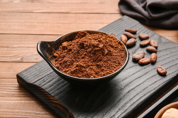Miska z kakao w proszku i fasoli na drewnianym tle - Zdjęcie, obraz